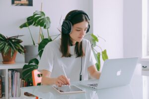 Mulher trabalhando com um tablet e escutando música