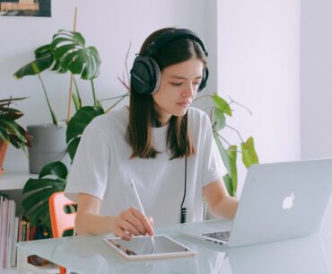 Mulher trabalhando com um tablet e escutando música